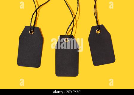 Group of three Blank black tags isolated on yellow background. Template Mock up Stock Photo