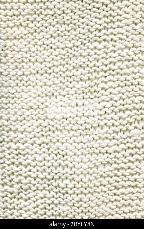 Warm white fabric sweater made of wool. White knitted boho fabric texture with blank space for ads. Stock Photo