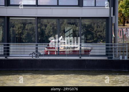 Reflection of an anchored motorboat on a floating building on the Danube River in Zemun, Serbia Stock Photo