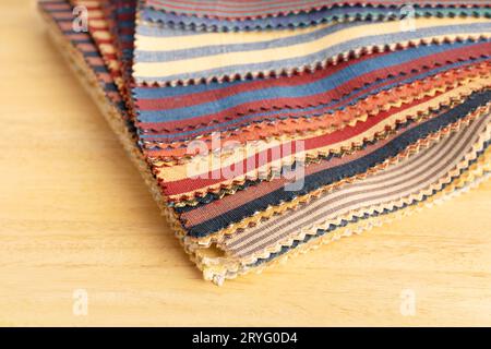 Fabric textile catalog on wooden table. Fabric samples upholstery and decoration. Stock Photo