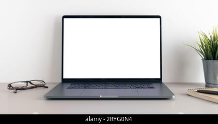 Modern laptop with blank white screen on minimalist desk. Mock up template Stock Photo