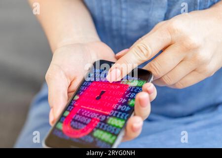 Mobile phone in female hands with screen showing compromised virus infected device. Cyber attack. Stock Photo