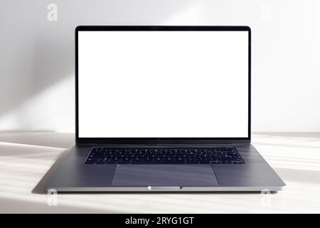 Modern laptop with blank white screen on minimalist desk Stock Photo