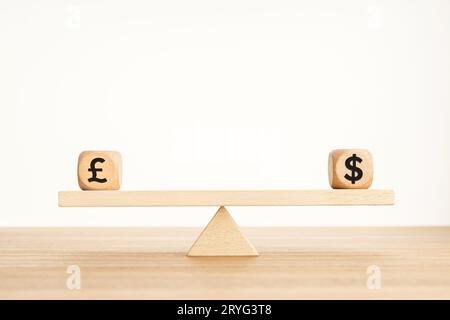 Pound and dollar parity concept. Sterling and US dollar symbol on wooden cube shape on a seesaw. Copy space Stock Photo