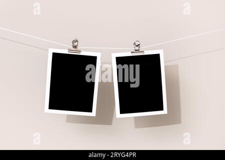 Two Blank Vintage instant photo frame hanging on a rope Stock Photo