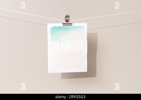 Instant photo frame with green and beige patches hanging on a rope Stock Photo