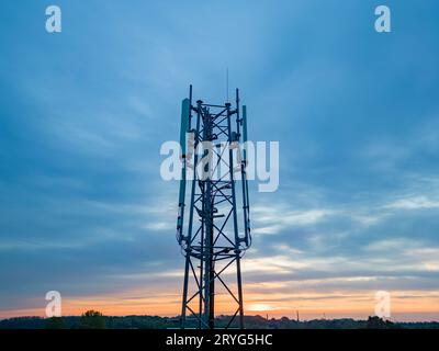 3G, 4G, 5G. Mobile phone base station Tower. Development of communication system in non-urban forest area with dark sunset or su Stock Photo