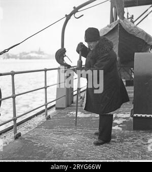 Winter at sea in the 1940s. Pictured a crewmember of the swedish icebreaker Ymer breaking the ice in the inner waters at the swedish coast in febrary 1941. The icebreaker Ymer was built in Malmö 1931-1933 and served as a state icebreaker for 44 years until she was sold and scrapped 1976. The winters during the World war II was often exceptionally cold and the ice became a big problem for the shipping industry and for the military. Ymer was the first big sea icebreaker using a diesel electrical propulsion system, a way of powering ships that today is common. The winters during the time of the w Stock Photo