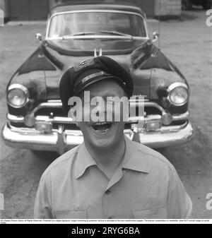 In the 1950s. A man by his car and he is seen being happy and smiling. Perhaps not so strange as he is the owner of an impressive American car of the brand Chrysler Imperial. In the 1950s, many details were chromed: grill, bumpers, moldings. Sweden 1951. Kristoffersson ref BP30-8 Stock Photo