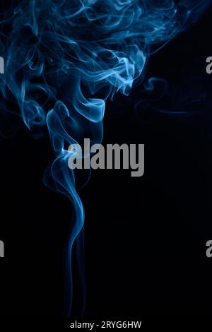 A vertical shot of blue tobacco smoke on a black background Stock Photo