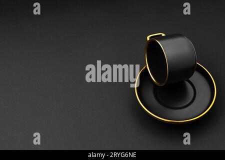 A set of black and golden ceramic plates and cup on a black background Stock Photo