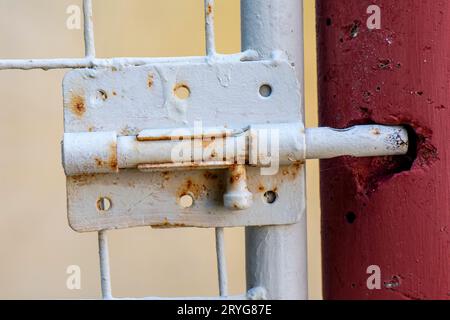 rusty old door bolt with hole in wall to accommodate bolt. Stock Photo