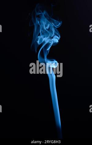 A vertical shot of blue tobacco smoke on a black background Stock Photo