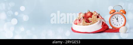 Conceptual photo of meeting the new year, alarm clock and Christmas tree decorations in Santas hat Stock Photo