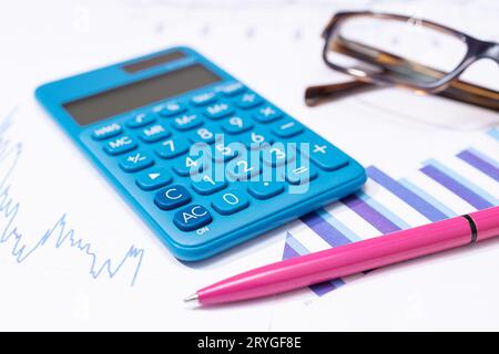 Business financial report background. Calculator, pen, eyeglasses and charts on work desk Stock Photo
