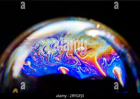 Multicolored abstract chaotic pattern inside of the soap bubble, closeup Stock Photo