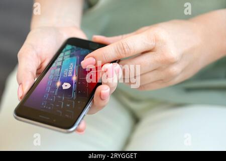 Mobile phone in female hands with screen showing compromised virus infected device. Cyber attack. Stock Photo