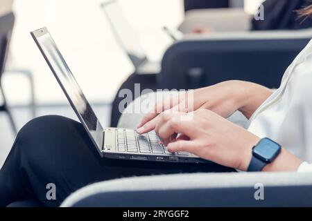 Millennial woman typing on laptop. Hands with computer in frame. Stock Photo