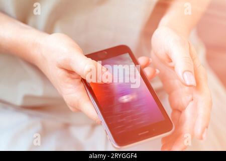 Mobile phone in female hands with screen showing compromised virus infected device. Cyber attack. Stock Photo