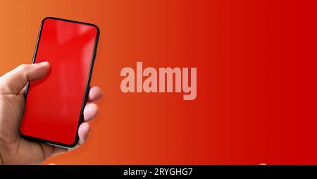 Hand holding a smartphone with blank red screen. Colorful horizontal banner. Stock Photo