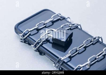 Phone security and data privacy concept. Smartphone locked with chain and padlock Stock Photo