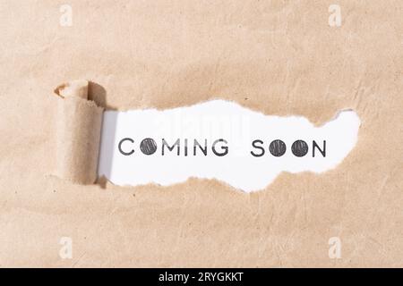 Coming soon message on torn paper Stock Photo