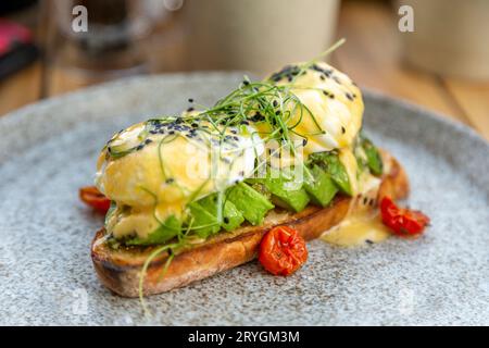 Poached eggs and avocado toast on the plate, healthy breakfast option Stock Photo