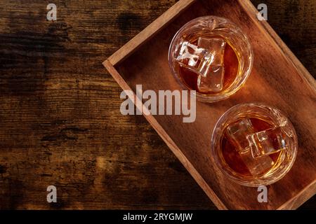 Whiskey in glasses with ice. Bourbon whisky on rocks on a dark background Stock Photo