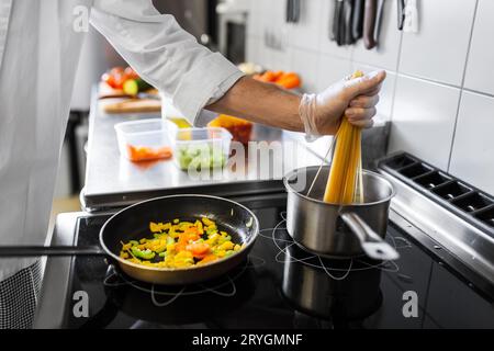 close up of chef cooking food at restaurant Stock Photo