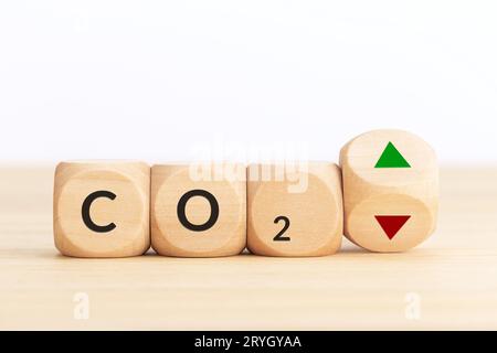 CO2 emissions up or down concept. Symbol on wooden blocks and turning dice with up and down arrows. Copy space Stock Photo