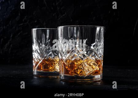 Whiskey in glasses with ice. Bourbon whisky on rocks on a dark background Stock Photo