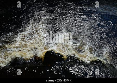 Water falling over a weir on the river Wharfe at Bolton Abbey, North Yorkshire. Stock Photo