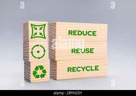 Reduce Reuse Recycle Icons and words on wooden blocks on gray background Stock Photo