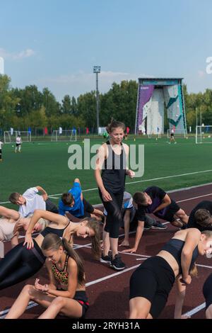 Female coach and group of children conducts a training session Stock Photo