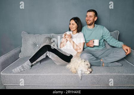 Happy smiling couple drinking coffee relaxing on couch Stock Photo