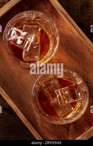 Whiskey in glasses with ice. Bourbon whisky on rocks on a dark background Stock Photo