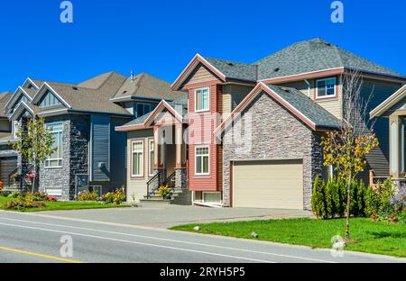 New family house with concrete driveway and asphalt road in front. Stock Photo