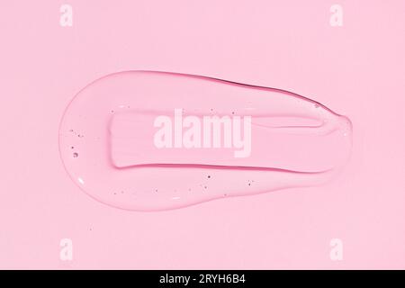 Liquid gel or beauty serum texture isolated on pink background. Transparent cosmetic skincare product. Close up Stock Photo
