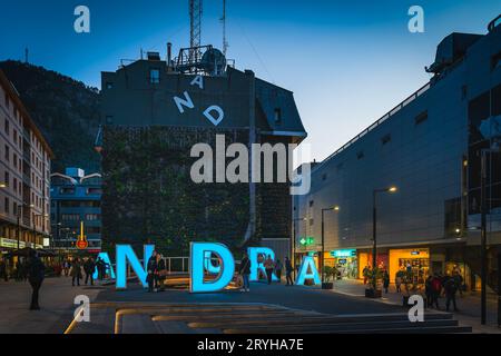 People taking pictures of iconic neon letters forming sign Andorra at night Stock Photo