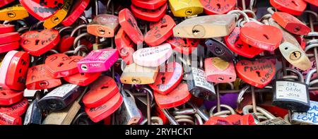 Verona, Italy - June 2022: background of heart-shaped locks on a wall, symbol of love forever. Stock Photo