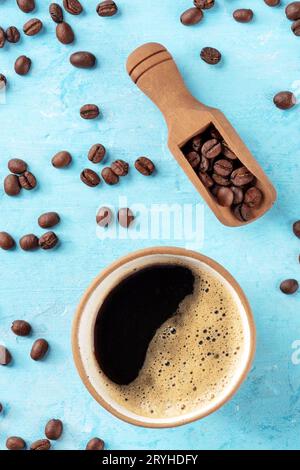 Coffee cup and beans in a scoop, shot from above on a blue background Stock Photo