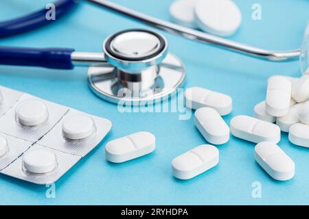 Healthcare medicine background. Close up of Stethoscope and medicine pills on blue background Stock Photo