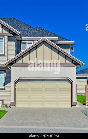 Double wide garage door of residential house with concrete driveway in front Stock Photo