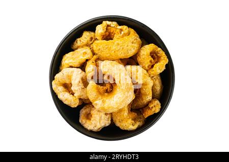 Top view of homemade crispy delicious deep fried pork rinds in black ceramic bowl. Stock Photo