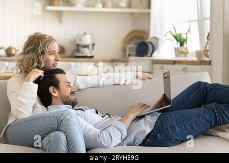 Couple spend time on internet resting on sofa using laptop Stock Photo