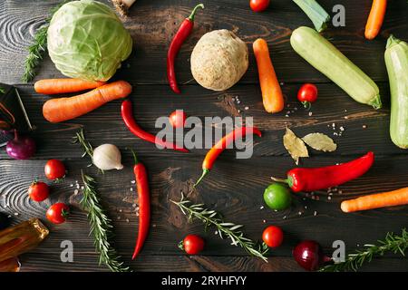 Top view of various fresh vegetables and herbs on dark wooden table Stock Photo