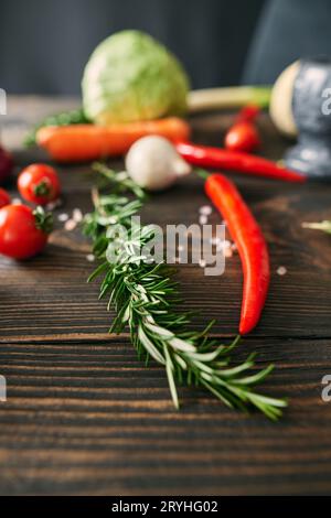 Healthy food. Vegetables and herbs on dark wooden kitchen table Stock Photo