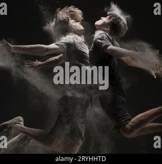 Two young dancers jumping in cloud of dust view Stock Photo