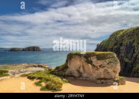 Whit rocks, cliffs and sandy beach at Ballintoy Harbour, Northern Ireland Stock Photo