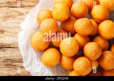 Fried sweet potato balls are a common Thai street sweet made predominantly from sweet potato and tapioca starch closeup on the wooden table. Horizonta Stock Photo